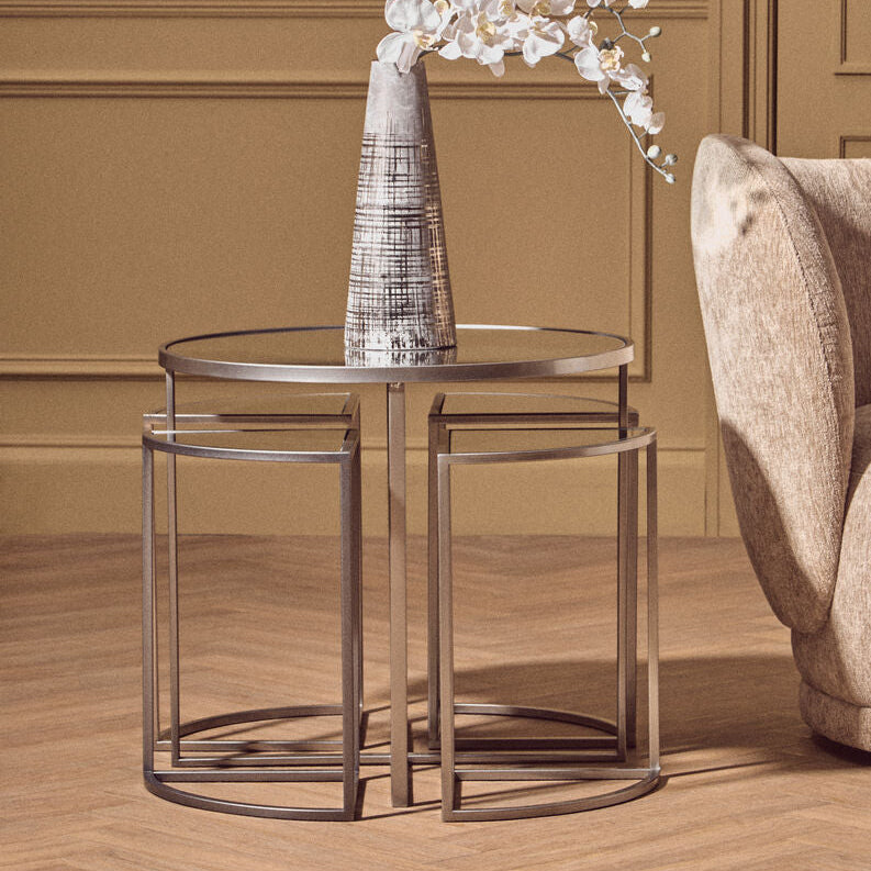 Decorative table with a vase and flowers against a wall with a framed picture.