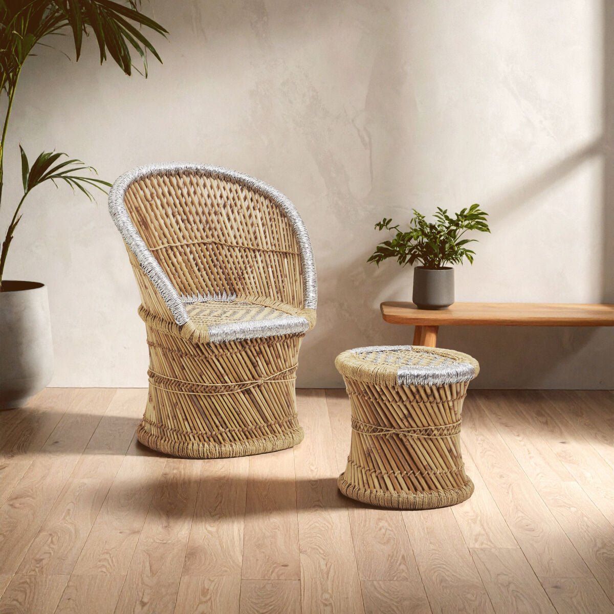 Wicker chair and ottoman set with a plant and wooden table in the background.
