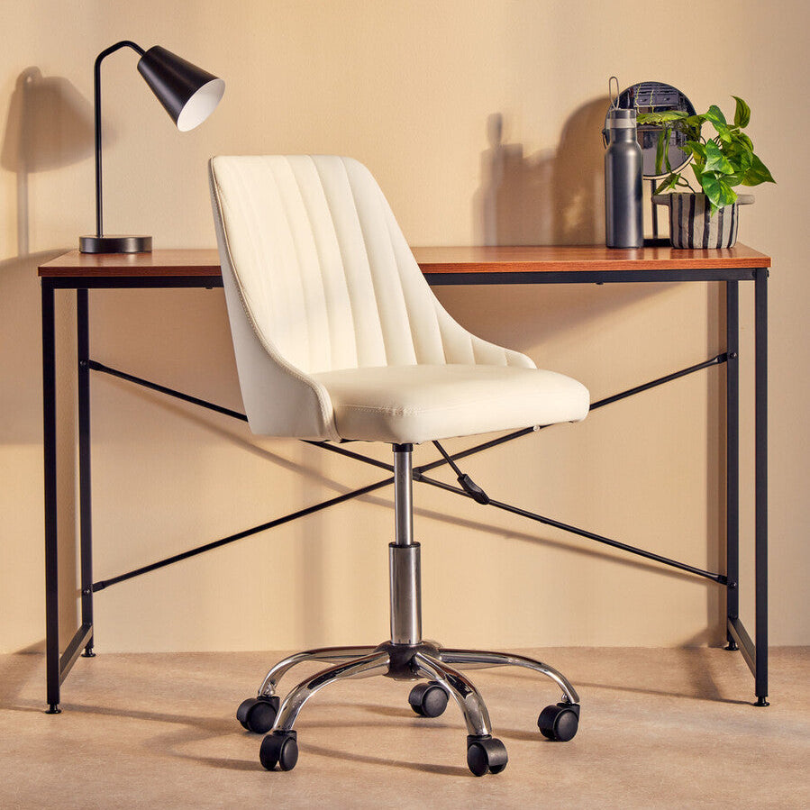 White office chair in front of a wooden desk with a lamp and plants on a beige wall background