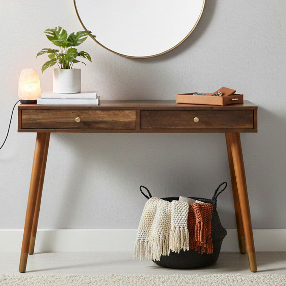 Wooden console table with decorative items against a plain wall