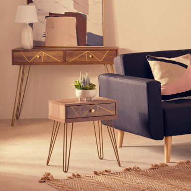 Modern living room with a blue sofa, side table, and abstract painting.