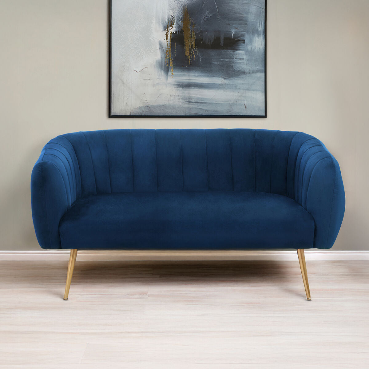 Blue sofa with gold legs in a room with a abstract painting on the wall.