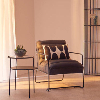 Modern armchair with a side table in a softly lit room