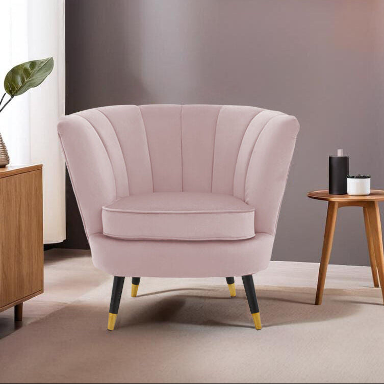 Pink armchair in a modern living room with wooden side table and abstract art on the wall.