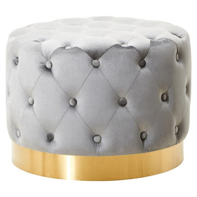 Gray tufted ottoman with a gold base on a white background