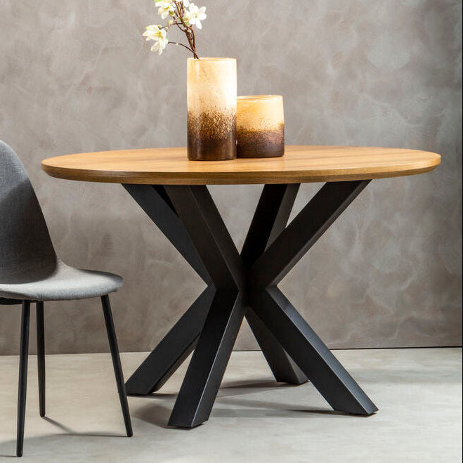 Wooden dining table with black metal legs and a gray chair against a gray wall.