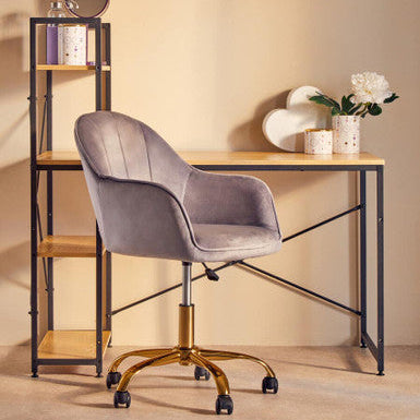 Gray chair in front of a wooden desk with a shelf against a beige wall.