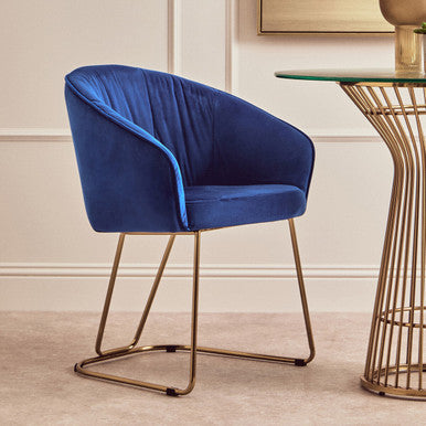 Blue chair with gold legs in a room setting