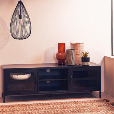 Black entertainment console with decorative items and a hanging lamp in a room.