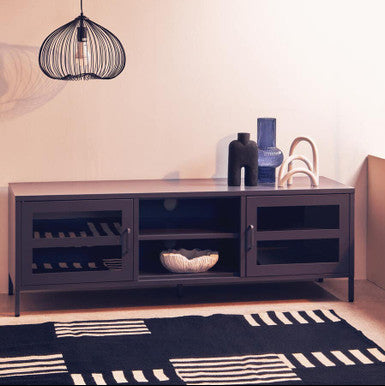Modern living room with a dark wooden TV stand, decorative items, and a hanging light fixture.