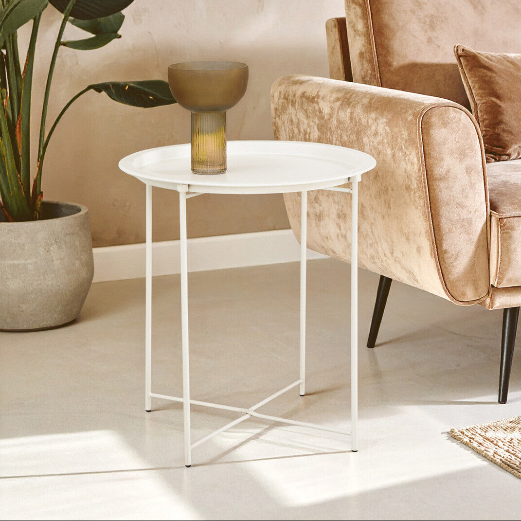 Beige armchair with a small round table and plant in a living room setting