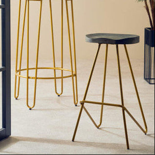 Two bar stools with gold metal legs on a light wooden floor.