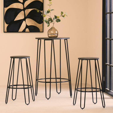 Three black metal stools and a small table against a beige wall with a decorative painting.