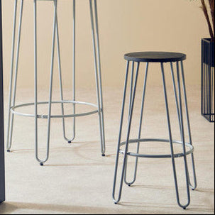 Two black bar stools with metal legs on a wooden floor.