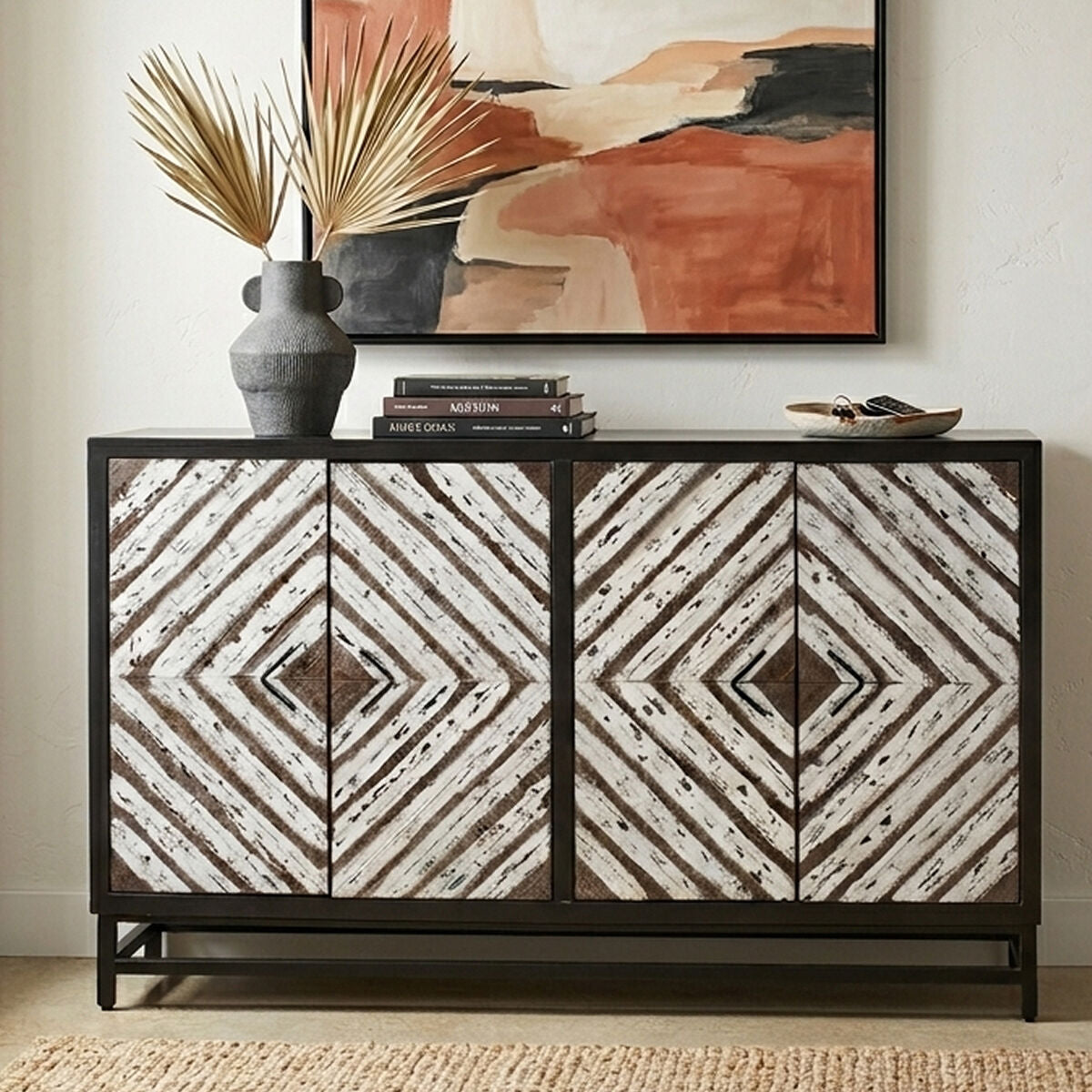 Decorative sideboard with geometric pattern, books, and a vase in a room setting.