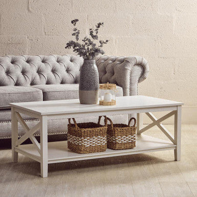 Living room with a gray sofa, white coffee table, and decorative items.