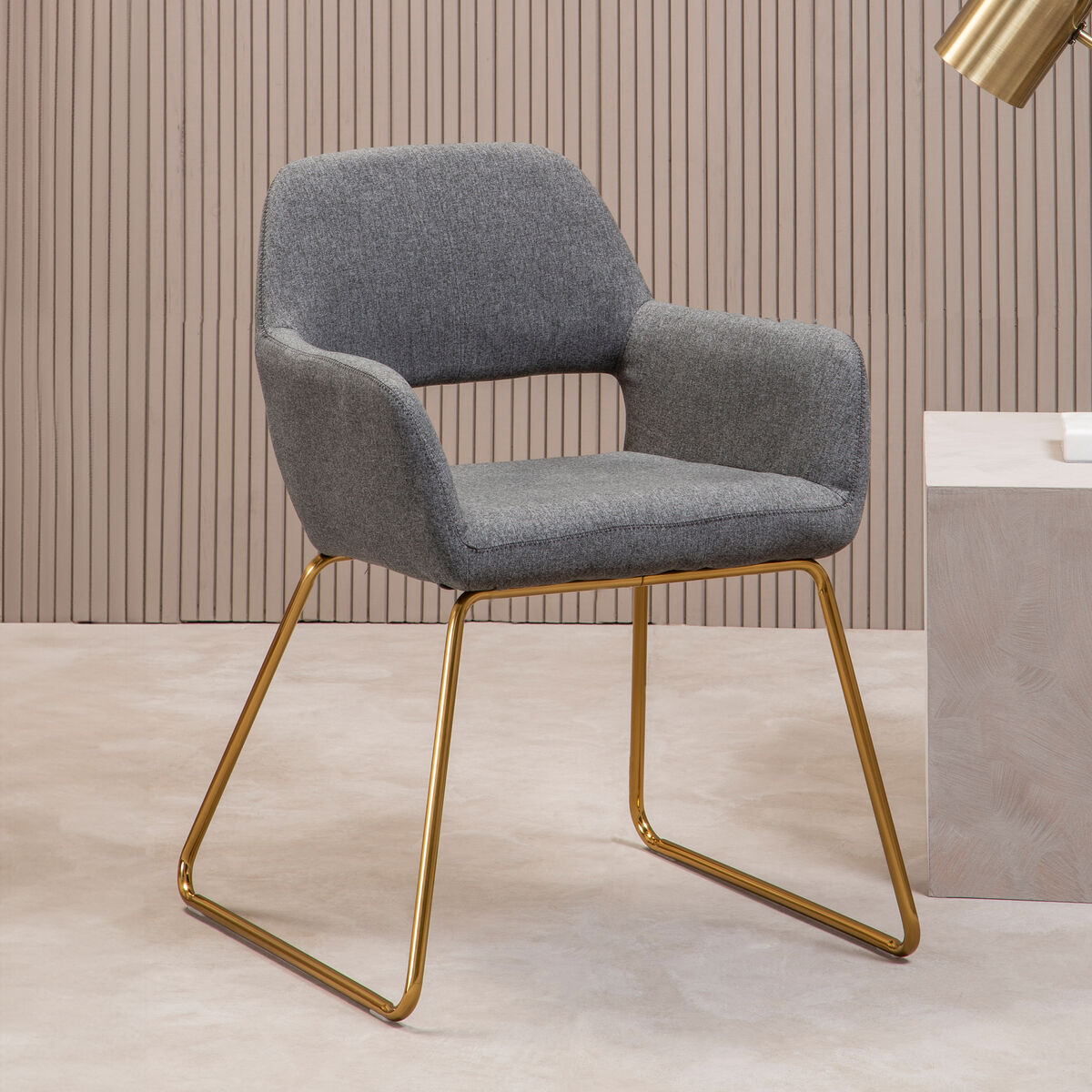 Gray upholstered chair with gold metal legs in a room setting