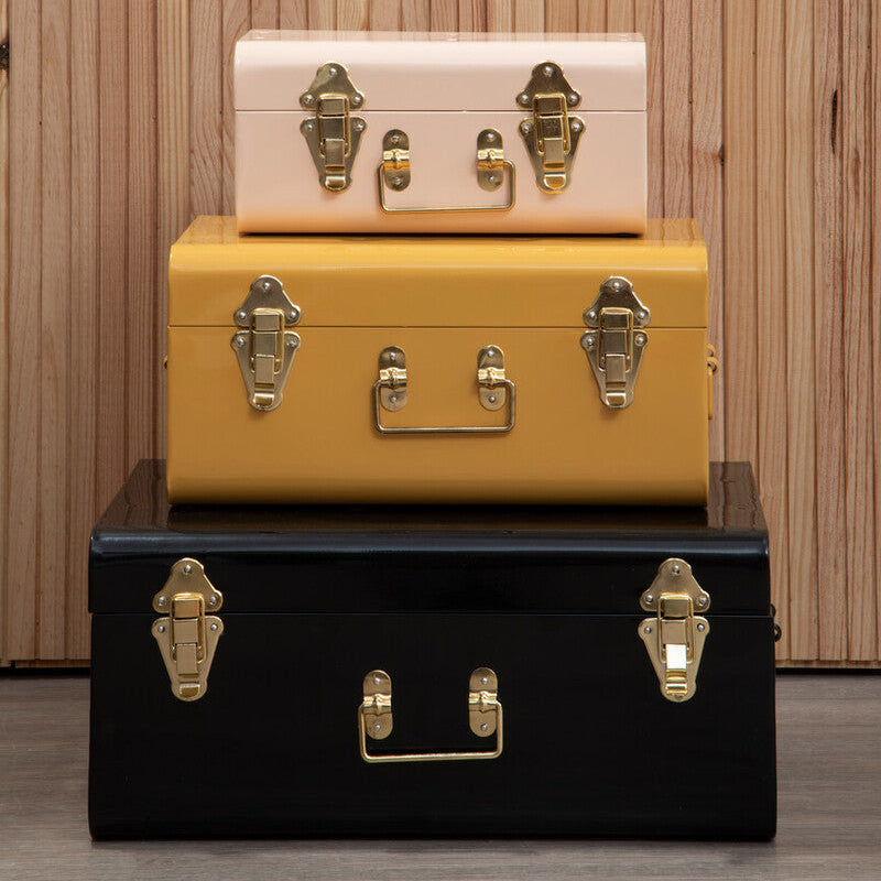 Stack of vintage-style suitcases with gold hardware against a wooden background
