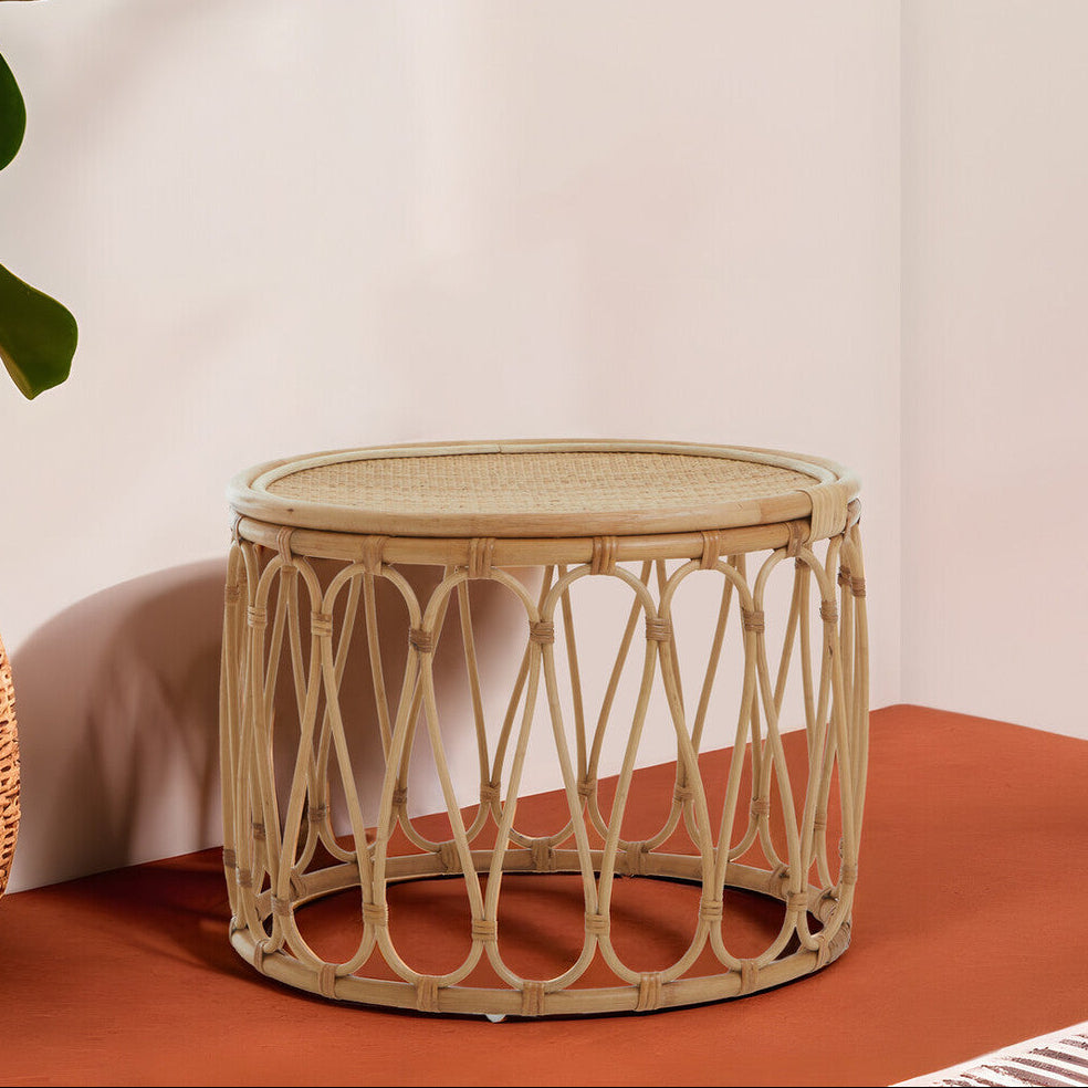 Wicker side table on a terracotta surface with a plain background
