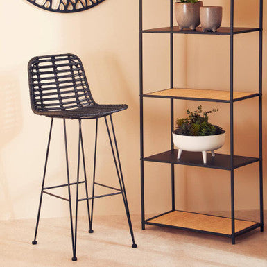 Black bar stool and metal shelving unit with decorative wall art in a room.