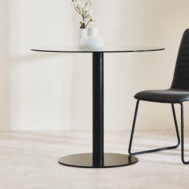 Black chair and table set against a beige wall