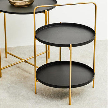 Set of three black round tables with gold frames on a light background
