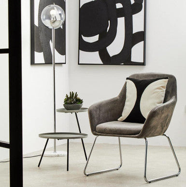 Modern chair with abstract art on a white wall