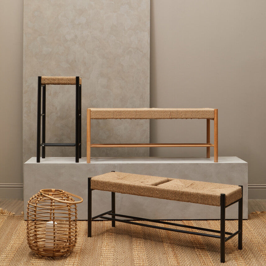 Set of wooden furniture including a stool, bench, and side table against a neutral wall.