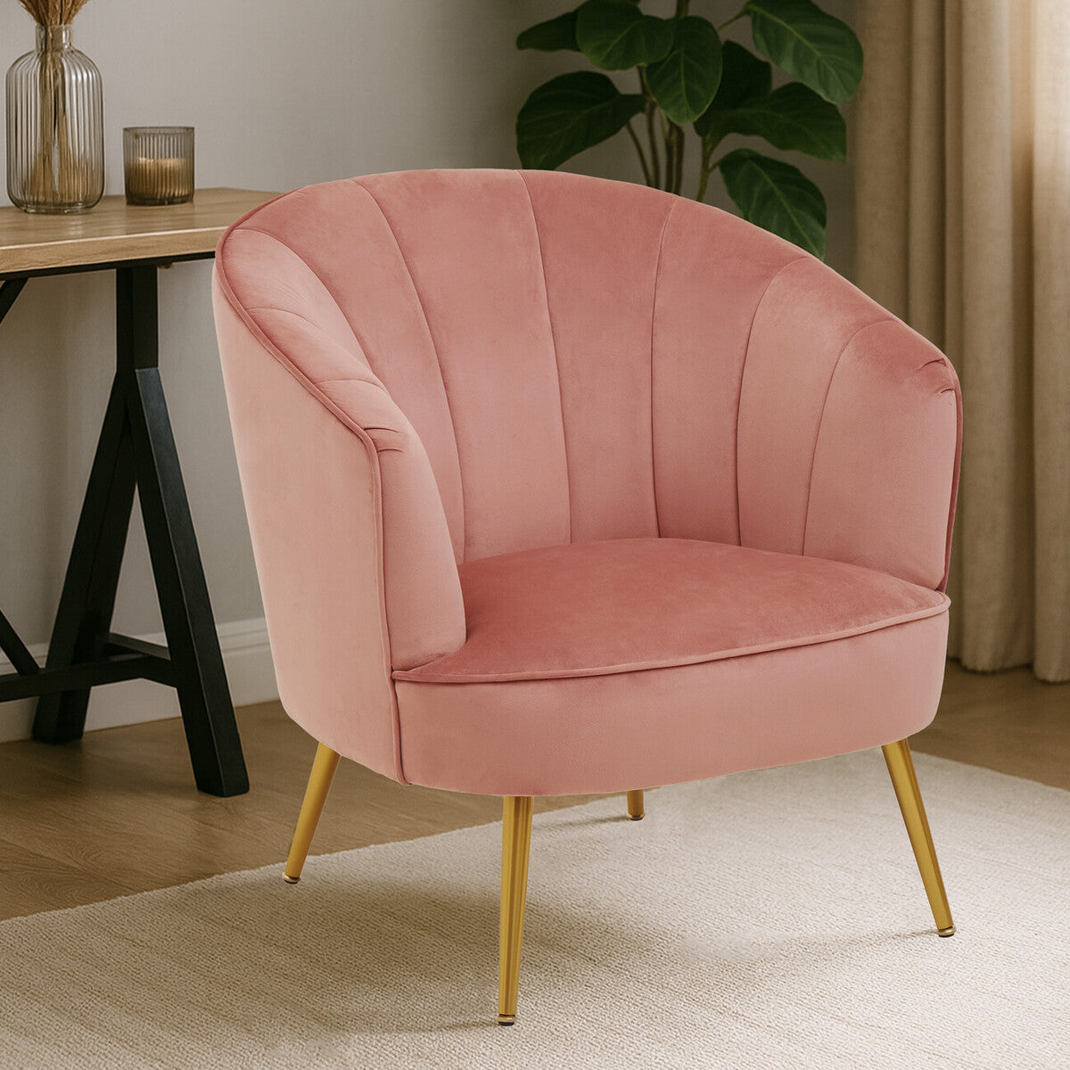 Pink velvet armchair with gold legs in a room setting.