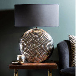 Decorative lamp on a side table against a teal wall