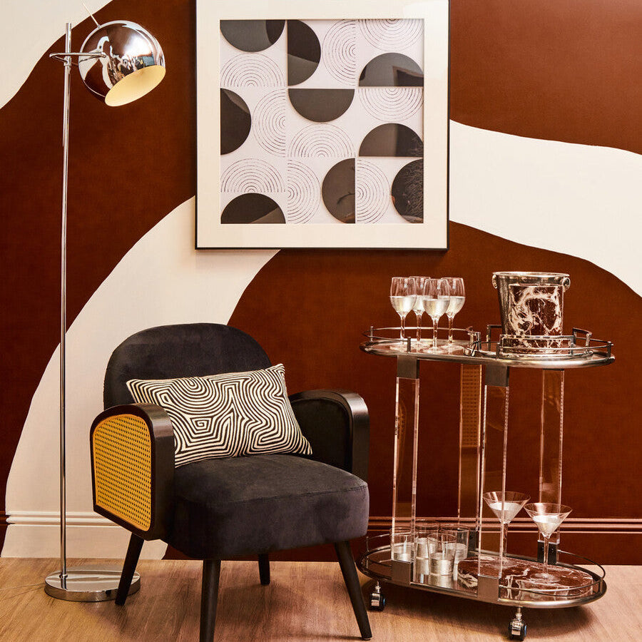 Modern interior with a chair, side table, and abstract art on a brown and white wall.