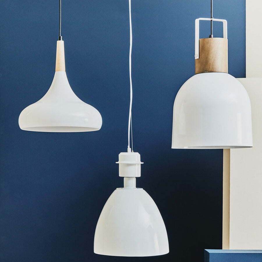 Three white pendant lights against a blue wall