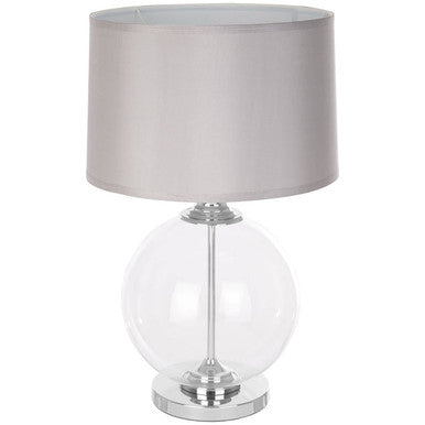 Table lamp with a clear glass base and gray fabric shade on a white background