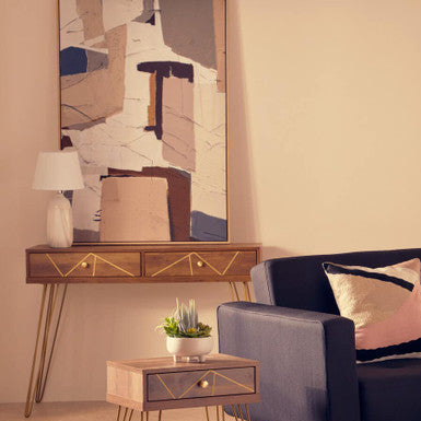 Modern living room with a blue sofa, side table, and abstract painting.