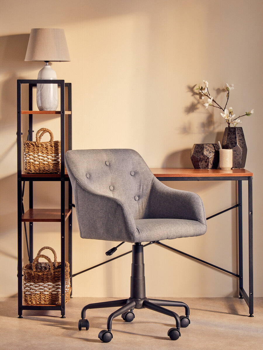 Gray office chair in a room with a wooden desk and shelves.