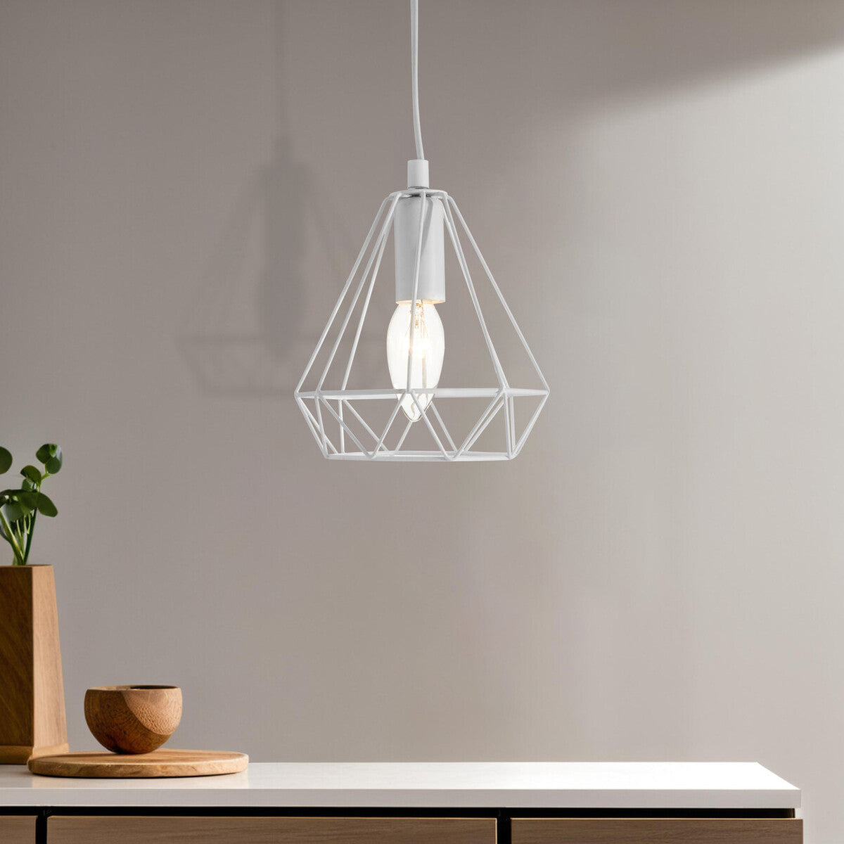 Modern pendant light hanging above a wooden surface with a neutral background