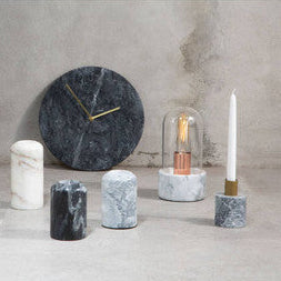 Decorative items including a clock, candles, and light bulbs on a neutral background