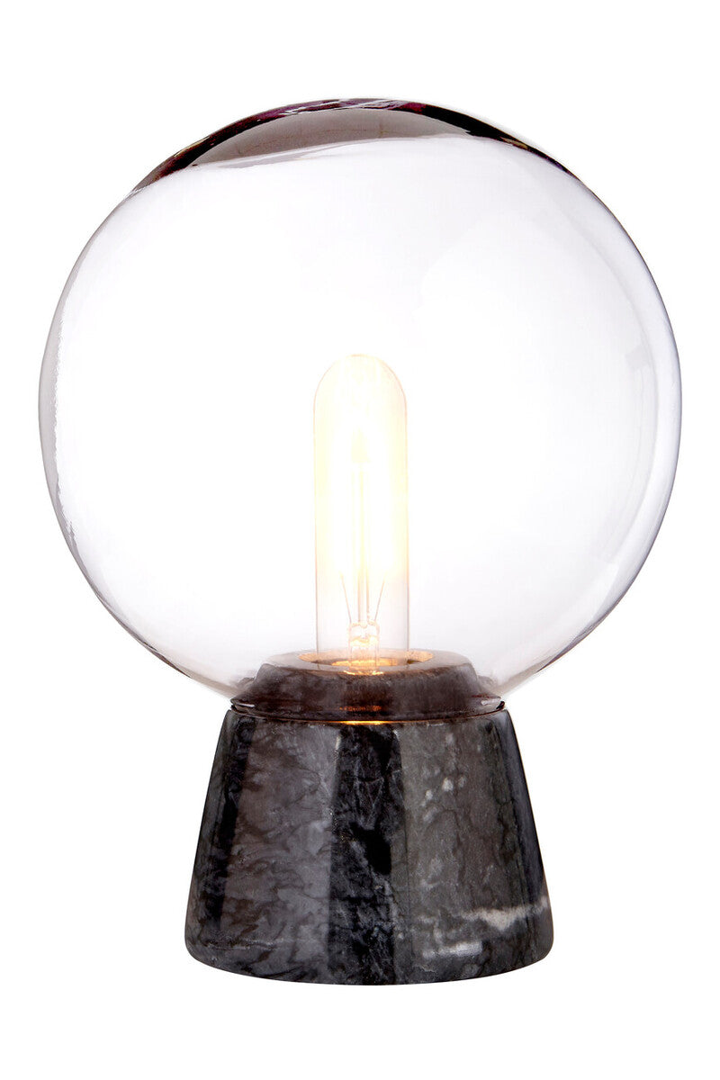 Table lamp with a glass globe shade and marble base on a white background