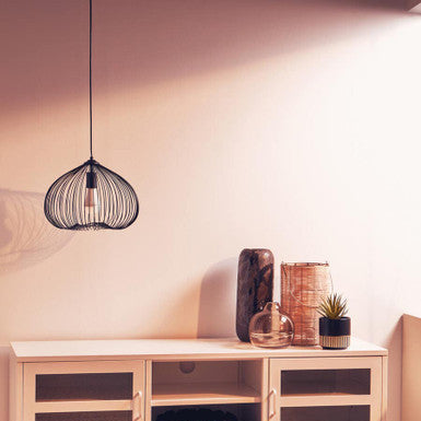 Light wood entertainment console with decorative items against a white wall.