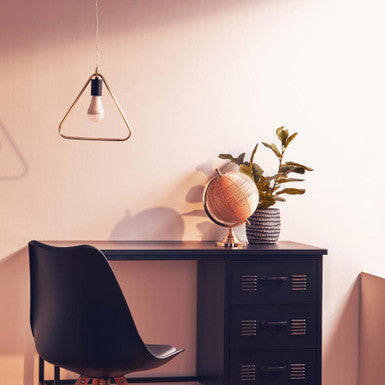 Modern office desk with black chair, globe, and plants in a room with warm lighting.