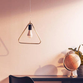 Modern office desk with black chair, globe, and plants in a room with warm lighting.