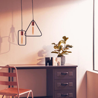 Modern office desk with chair, lamp, and plant in a stylish room.