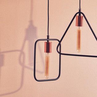 Two modern pendant lights with geometric frames on a neutral background