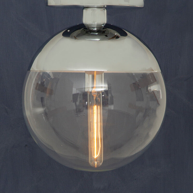 Clear glass globe light fixture with visible filament against a dark background