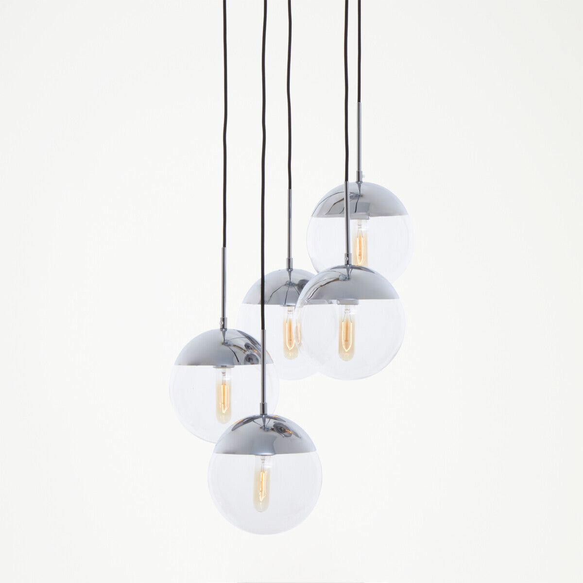 Set of four pendant lights with glass shades and chrome fixtures on a white background