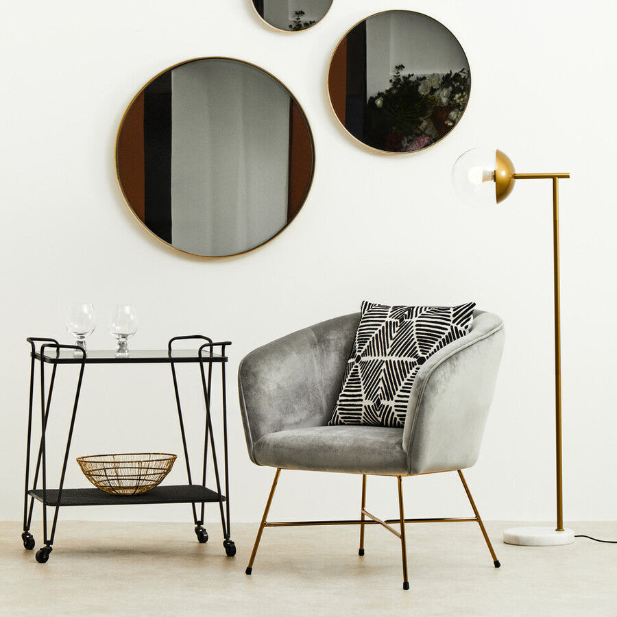 Modern interior with a gray armchair, side table, and floor lamp against a white wall.