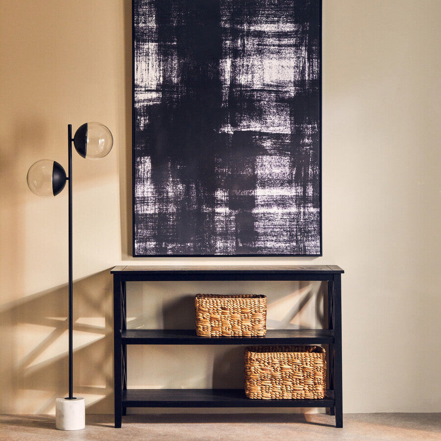 Modern interior with a black console table, abstract painting, and floor lamp.