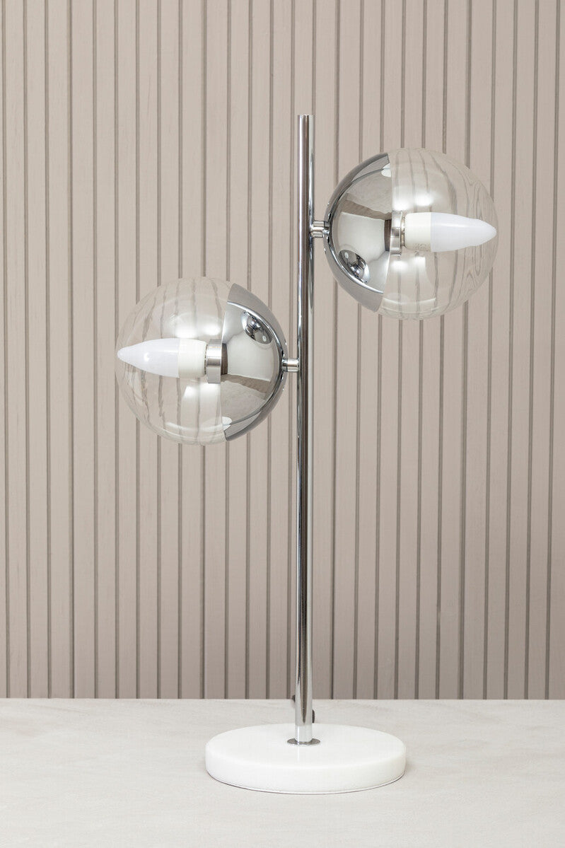 Modern floor lamp with glass shades against a striped wall.