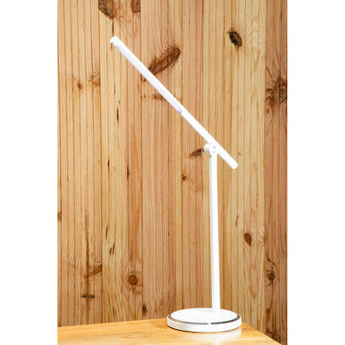 White LED desk lamp on a wooden surface with a wooden panel background
