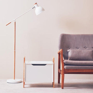 Modern living room with a gray sofa, white floor lamp, and wooden side table.
